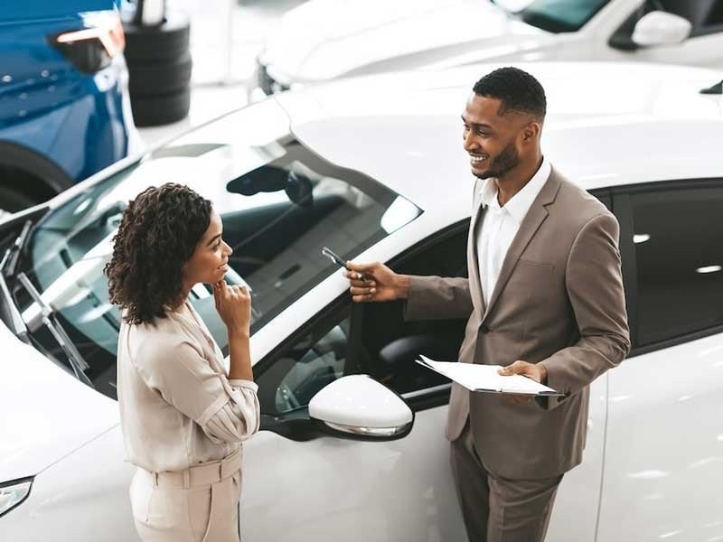 New automotive employee helping customer