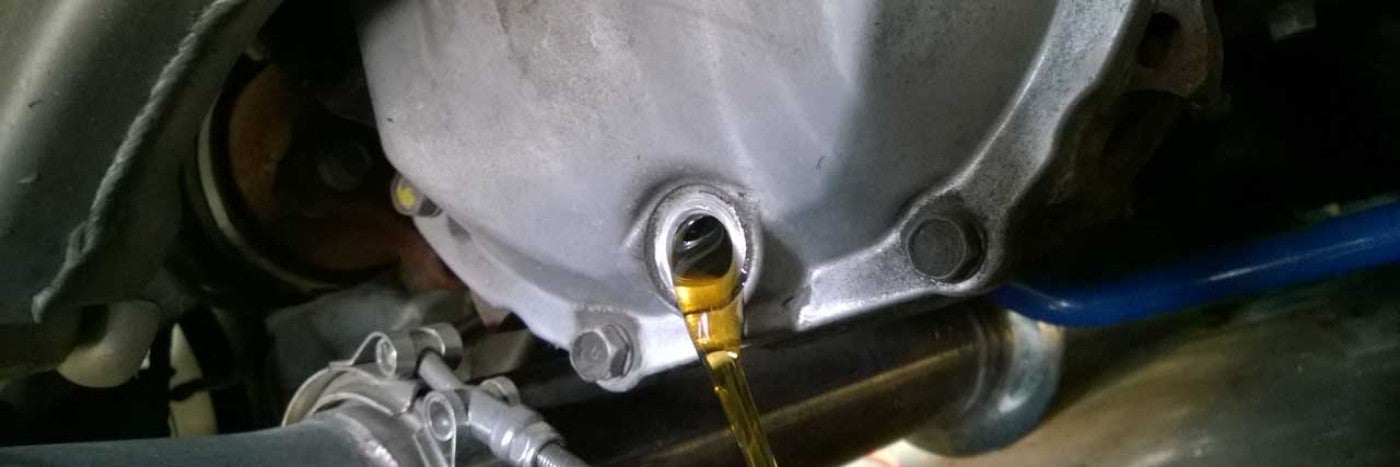 View of yellow colored liquid pouring from a metal tank