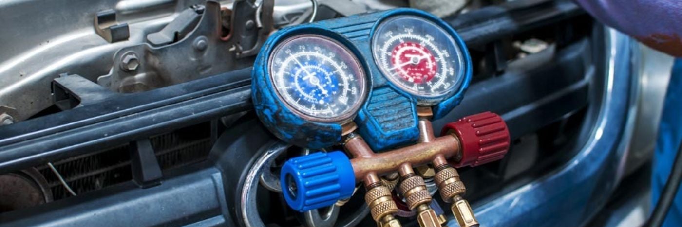 close up view of 2 gauges hooked up checking a vehicle's heating system
